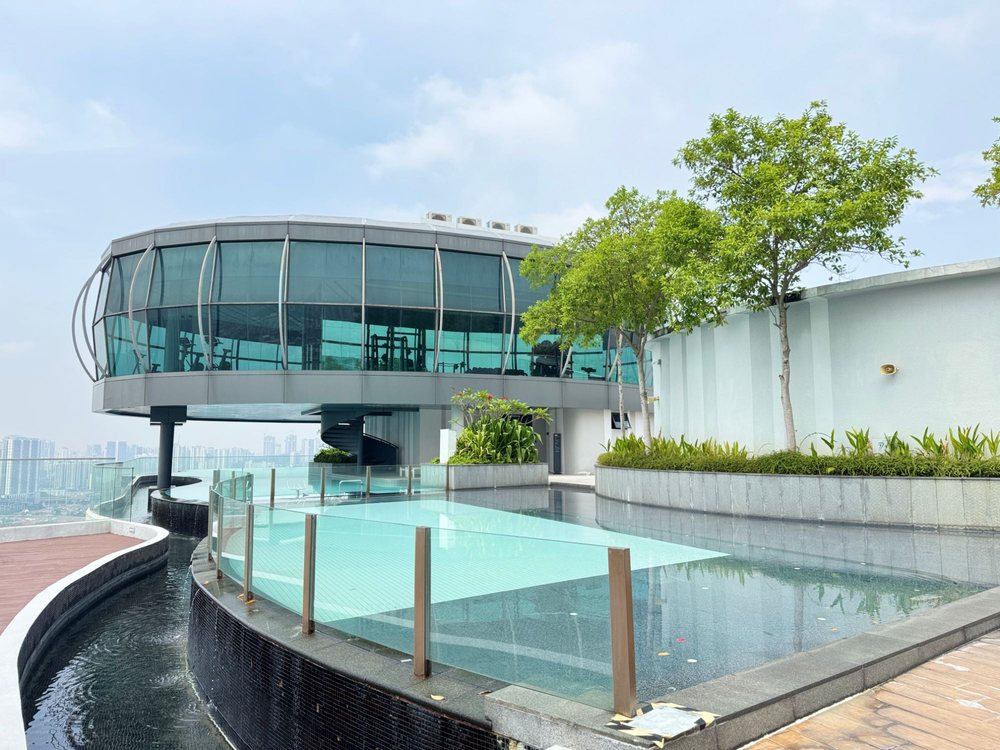Unio Residence rooftop infinity pool beside the glass gymnasium pod